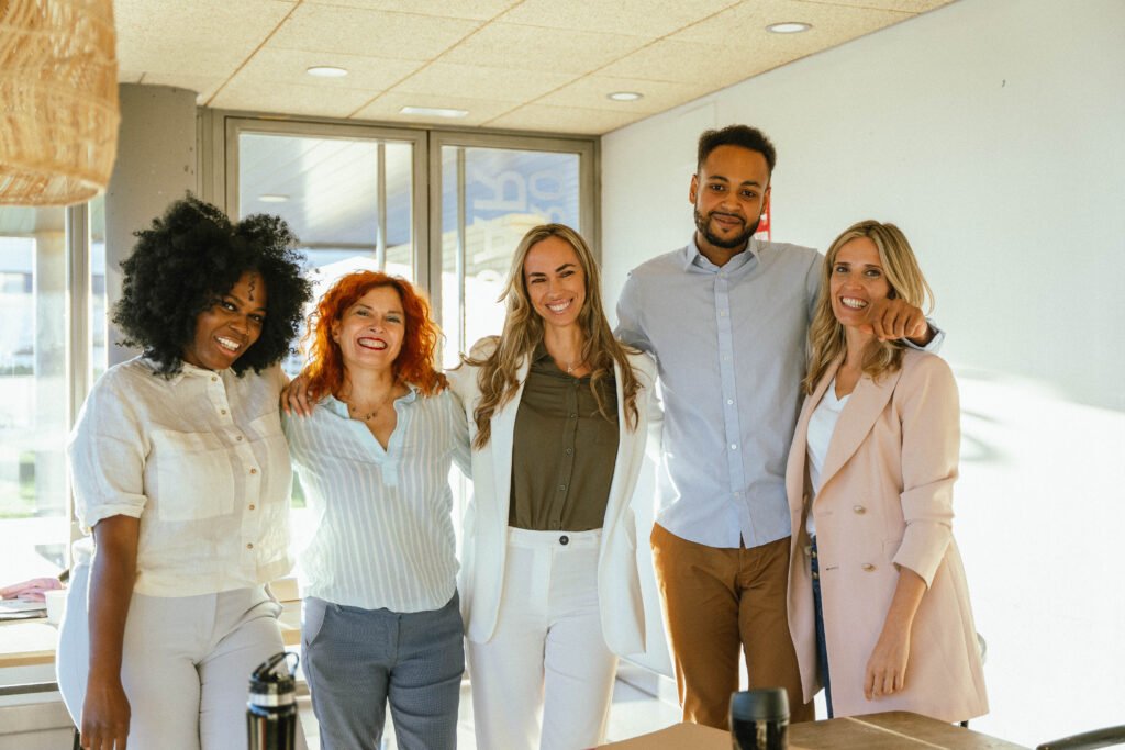 Multiethnic business team smiling while standing together in the office.